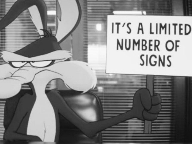 coyote-vs-acme-a-tale-of-two-conglomerates-1 Animated scene from Coyote vs. Acme showing a cartoon character holding a sign that reads "It's a Limited Number of Signs."