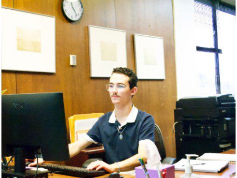 A person works at a computer in a philosophy department office.