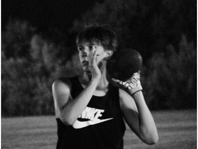 A student in athletic wear on the field during intramural flag football.