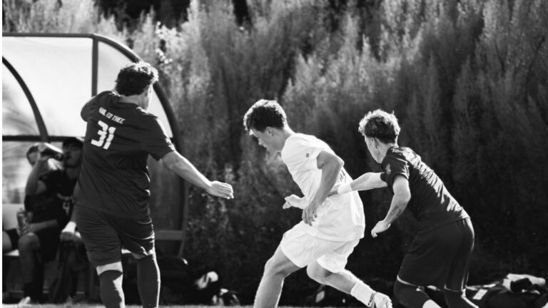 Soccer players from opposing teams competing for the ball during a match.